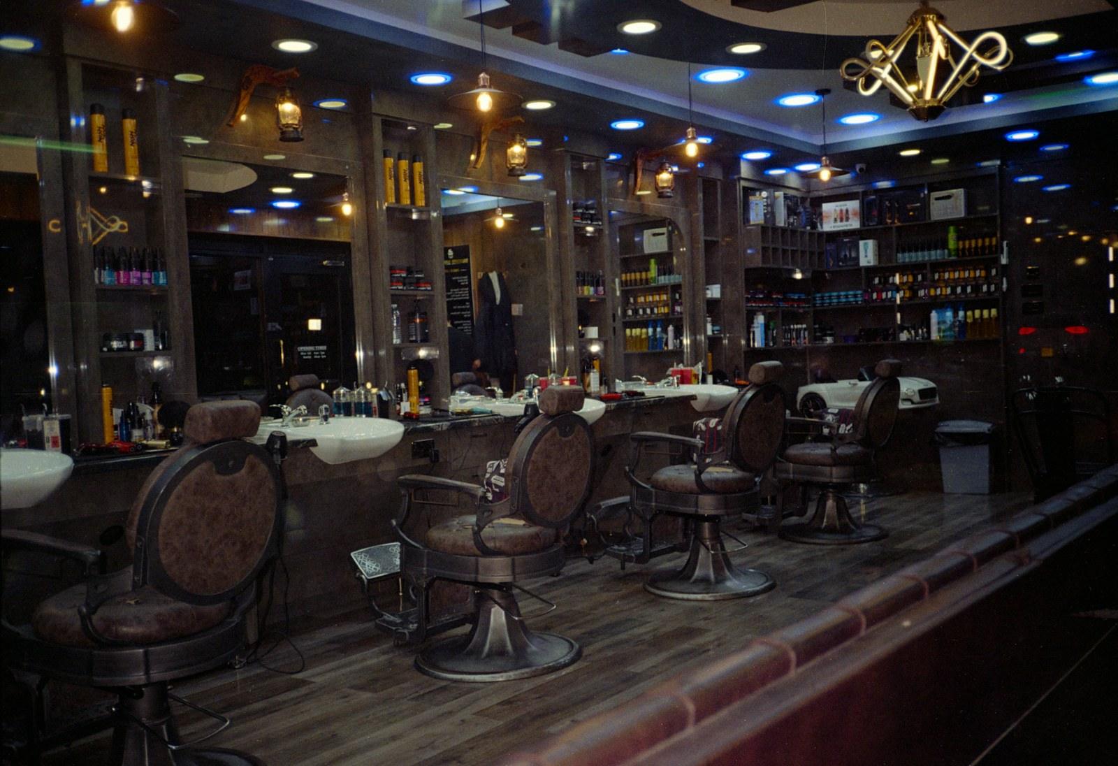 Golden-lit barbershop with vintage chairs and mirrors